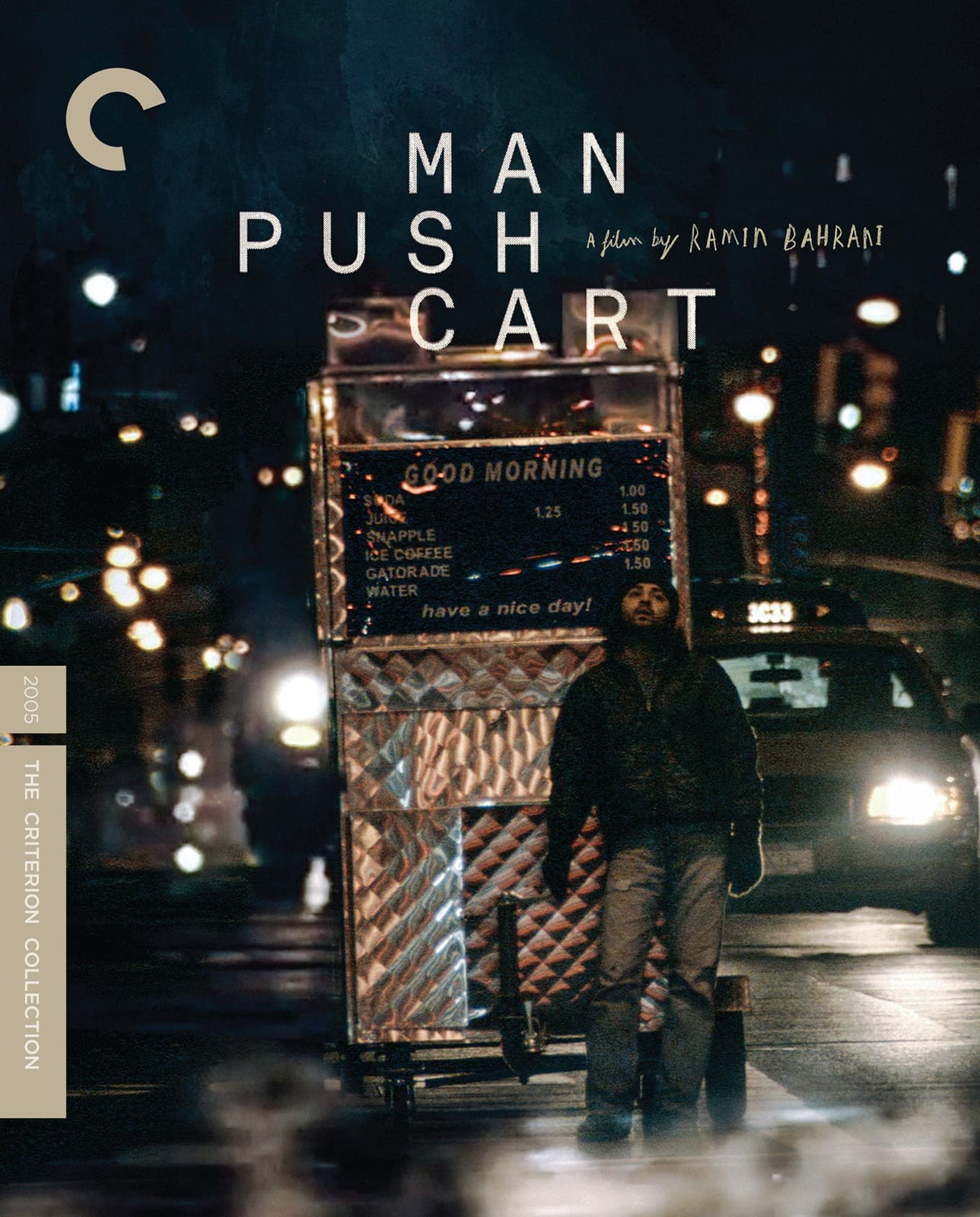 A man pulling a push cart in the night. 